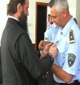 The police put handcuffs on Archbishop Jovan in front of the cameras